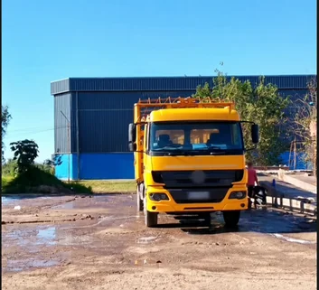 Frente de un camión Mercedes-Benz amarillo en el predio