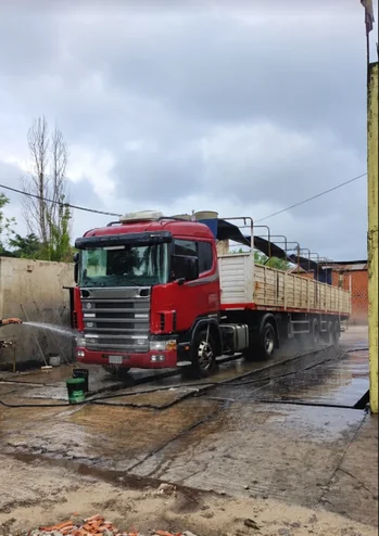 Camión Scania rojo con acoplado durante el lavado